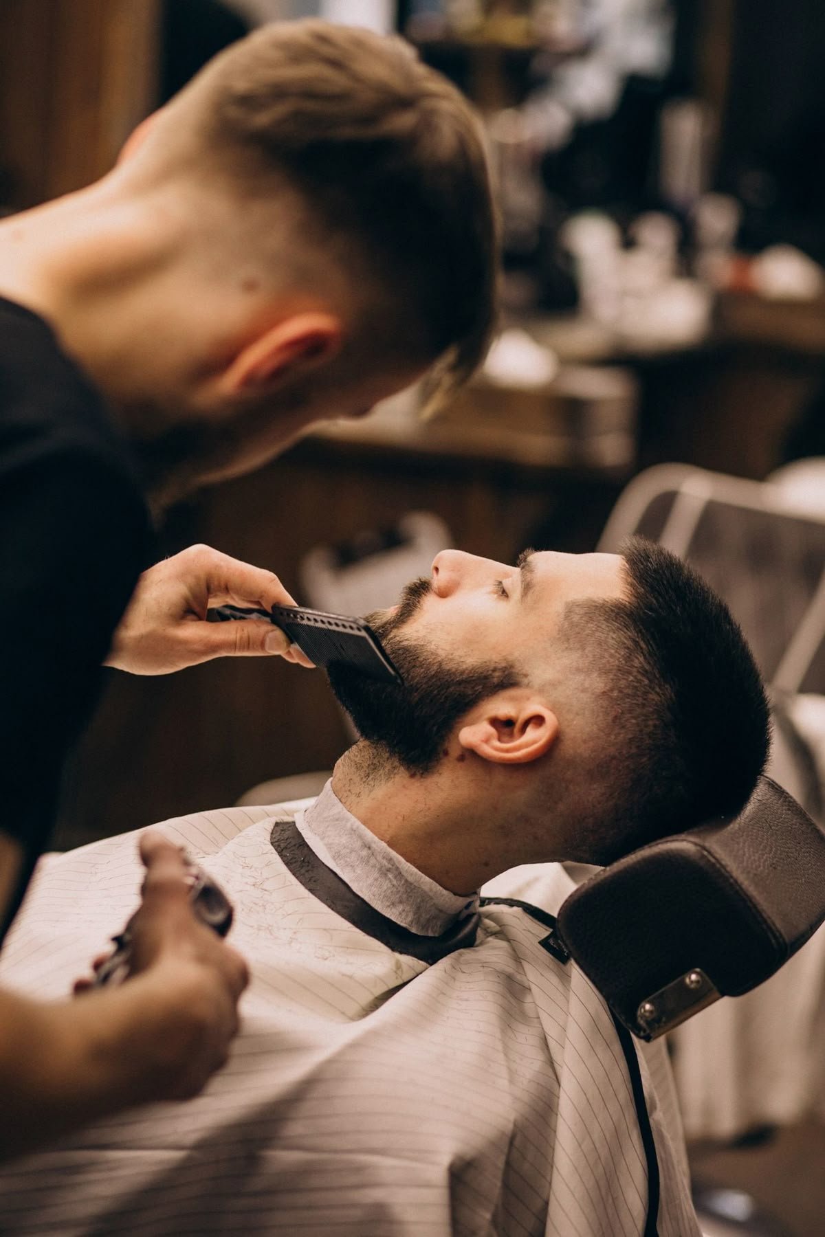 Skilled barber trimming a client's beard with precision